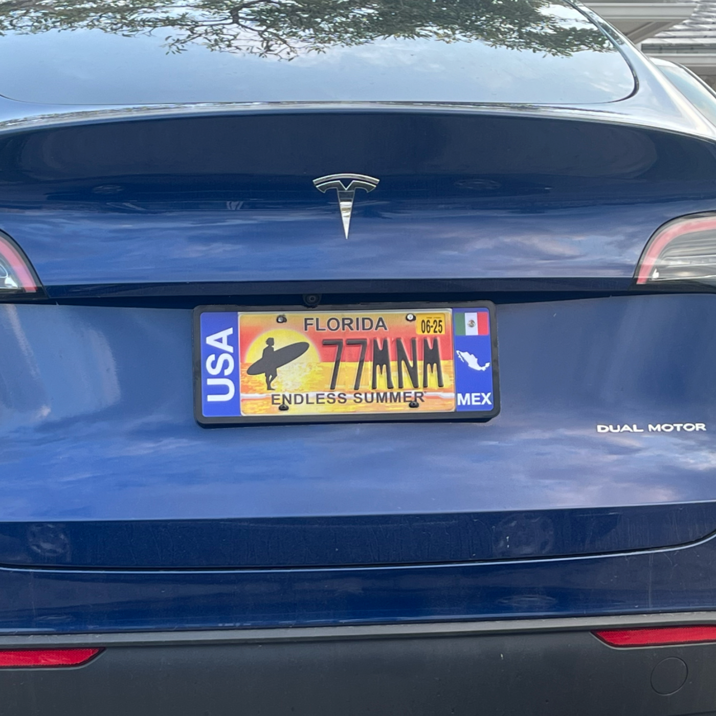 Blue Tesla car with a custom Mexican license plate frame patented by DFS