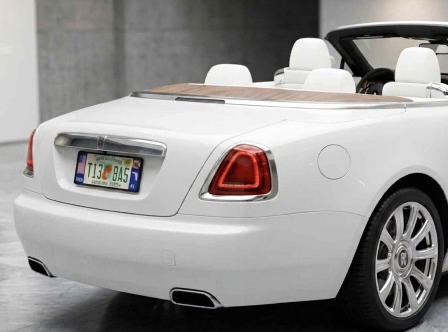 White Rolls-Royce convertible shown from the rear three-quarter angle, featuring the official DFS patented license plate frame. Option Florida.