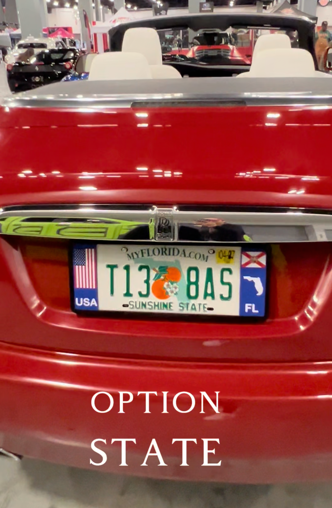 Red rolls royce with DFS Florida patented license plate frame in a showroom. DFS is the official license frame of America