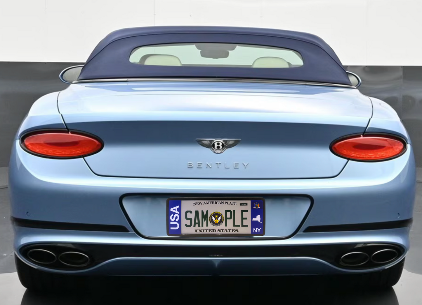 License plate frame with bold vertical USA text on the left mounted on a light blue Bentley convertible with a New York plate by DFS Brands.